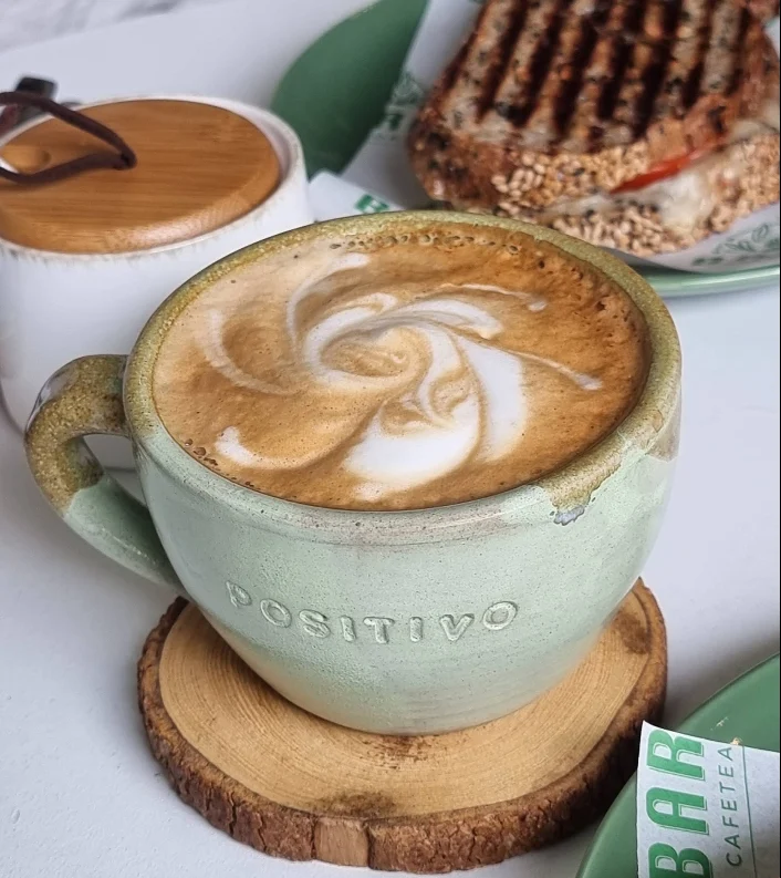 Taza verde con arte latte; imagen referencial